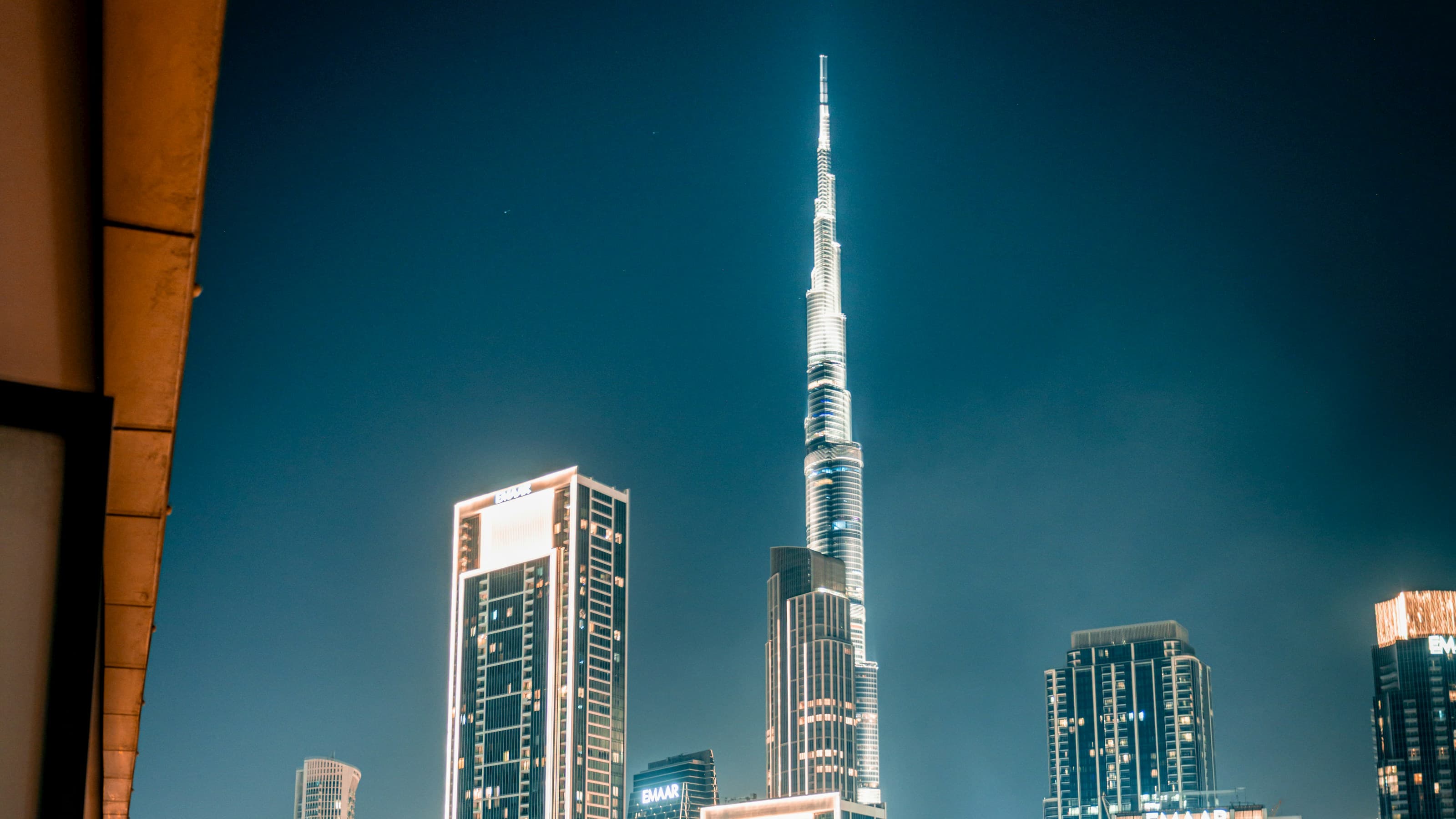 The Burj Khalifa towering over illuminated Downtown Dubai skyscrapers at blue hour